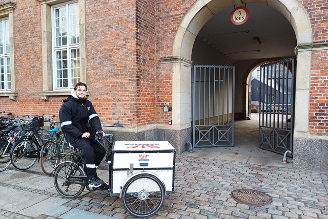 SIF medarbejder på sin ladcykel foran de nye lokaler i København